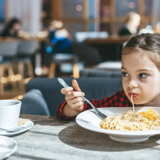 mała dziewczynka jedząca spaghetti