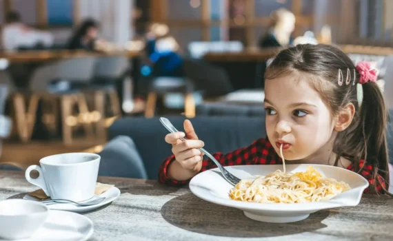 mała dziewczynka jedząca spaghetti